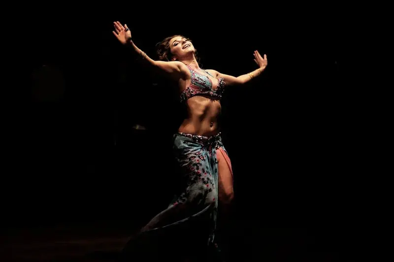 Belly dancer performing a solo under a single spotlight